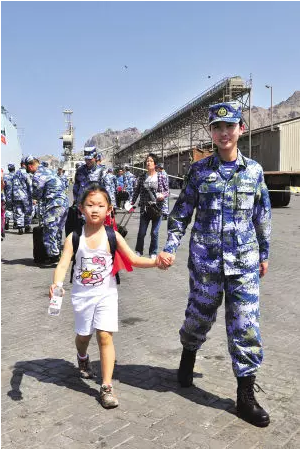 一名小女孩在舰员的带领下登舰撤离